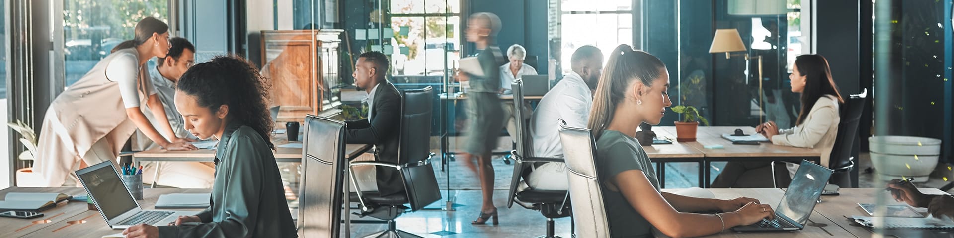 Business professionals working collaboratively in a modern open office space, representing DEME LLC’s executive assistance and business support services.